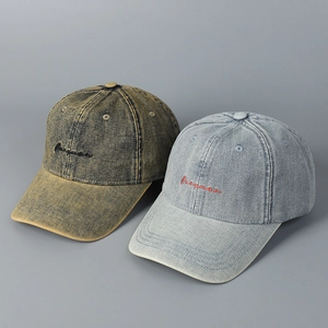 Close-up of vintage washed denim baseball caps with detailed cursive letter embroidery