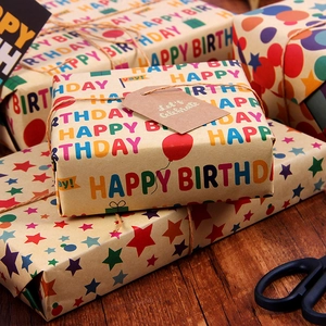 Birthday kraft paper gift wraps with colorful stars and polka dots on a wooden table