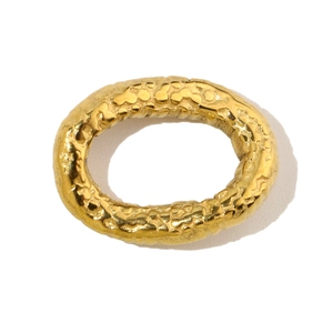Detailed view of oval golden stainless steel charm with hammered metal texture