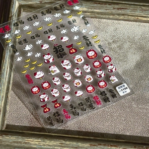 Detail view of Maneki Neko nail stickers with 5D embossed golden lucky cat patterns