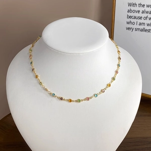 Detailansicht der goldenen Kette mit bunten Zirkon-Blumen auf einer weißen Schmuckbüste