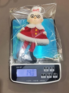 Detail view of plush Christmas ornament showing weight measurement on a scale