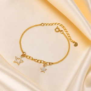 Detailed close-up of an 18K gold star bracelet with zircon stones on champagne silk fabric