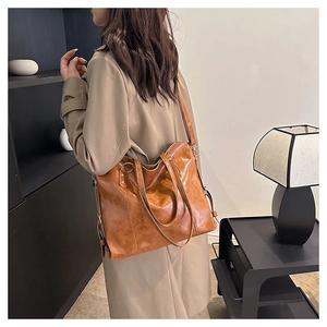 Brown vintage faux leather tote bag with double handles shown in a modern interior setting