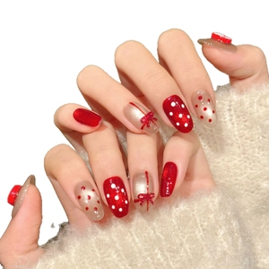 Handmade red and gold holiday press-on nails with 3D bows and festive polka dots