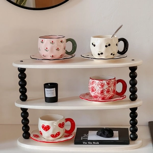 Macro view of hand-painted ceramic coffee cups and saucers with floral heart patterns