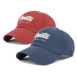 Detail of red and navy cotton baseball caps featuring white 3D Create NEW LIFE embroidery
