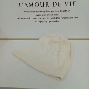 Close-up of cream knit beanie showing soft textured fabric and warm ribbed material