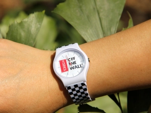 Close-up of white silicone watch with checkerboard pattern and Off The Wall dial text