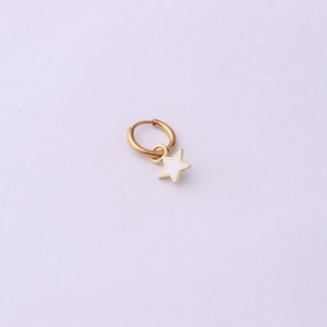Macro detail of gold-plated hoop earring with white enamel star pendant and smooth finish