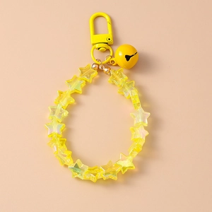 Detail of yellow star beads with a matching metal bell and lobster clasp on a keychain