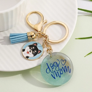 Detail of keychain with light blue suede tassel and resin charm featuring dog mom text