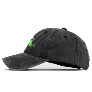 Close-up of mushroom embroidery on washed black cotton baseball cap with vintage texture