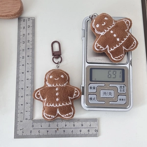 Detailed view of plush gingerbread man keychain with measurements and weighing scale