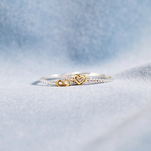 Macro shot of gold S925 silver infinity and heart rings with pavé zircon detail