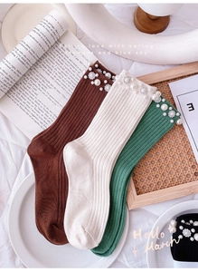Detailed macro view of cotton rib-knit crew socks with hand-beaded pearls and floral crystals