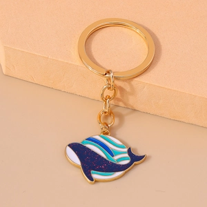 Vue macro d'un porte-clés baleine doré avec émail bleu scintillant et rayures fines
