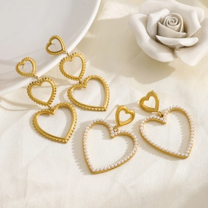 Elegant 18K gold layered heart earrings with pearls on white silk background