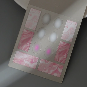 Dettaglio degli adesivi per unghie effetto marmo rosa e sfumato con glitter fini