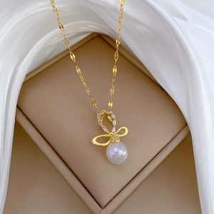 Elegant gold titanium steel necklace with bow pendant, shiny diamonds and a pearl charm