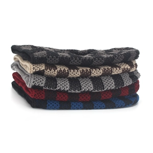 Detailed view of checkered knit beanies in five assorted colors with thick texture