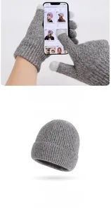 Detail of gray knitted beanie and touch screen gloves with white fingertips for winter