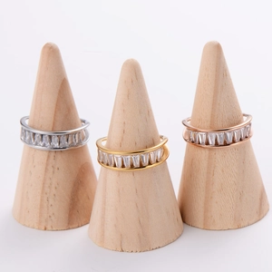 Set of three sparkling baguette cut zircon rings on wooden cone displays in gold and silver
