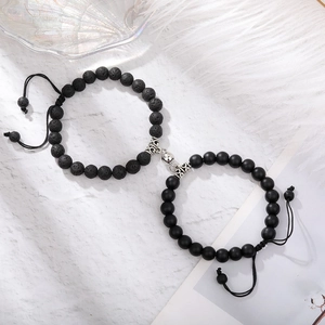 Detail of magnetic stone bracelets for couples with black lava beads and adjustable cord