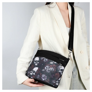 Gothic skull and floral print crossbody bag shown with a stylish casual outfit