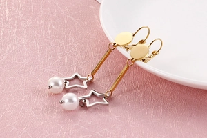 Détail de longues boucles d'oreilles étoile dorée avec perles blanches élégantes