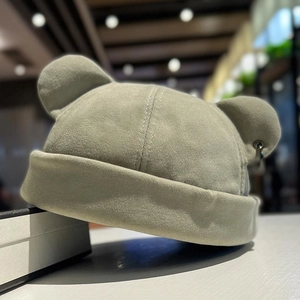 Close-up of light green docker hat with cute bear ears and metallic ring detail