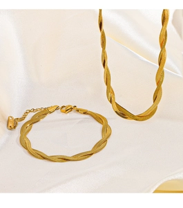 Detail of 18K gold-plated titanium steel necklace and bracelet set on silk