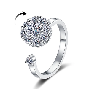 Adjustable silver spinner ring featuring a rotatable floral design with cubic zirconia