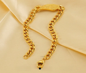 Gros plan détaillé du bracelet gourmette en acier inoxydable plaqué or 18 carats sur soie