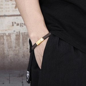 Détail du bracelet en cuir tressé noir pour homme avec plaque en acier inoxydable doré