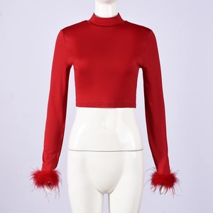 Detail of red mock neck crop top with luxurious feather cuffs and stretchy fabric
