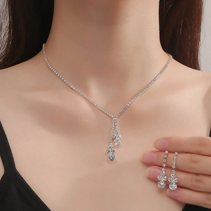 Detailed close-up of bridal jewelry set with sparkling teardrop zircon on a model