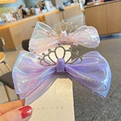 Detailed view of sequin bow hair clips with crown charms in pink and purple colors