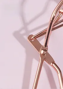 Dettaglio della cerniera centrale del piegaciglia in oro rosa con finitura metallica