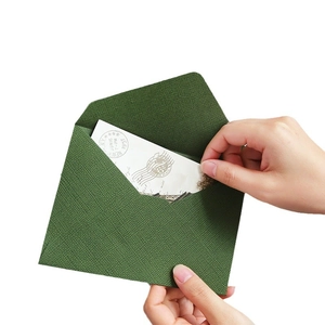 Vintage dark green linen textured envelope with retro air mail card on white background