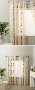 Detail of beige sheer lace curtain with embroidered cherry and bell floral patterns