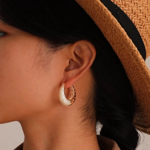 French vintage style hollow zircon hoop earrings in gold finish worn by a model