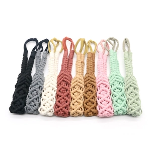 Macro detail of ten colorful handmade cotton macrame net bottle carriers in various shades