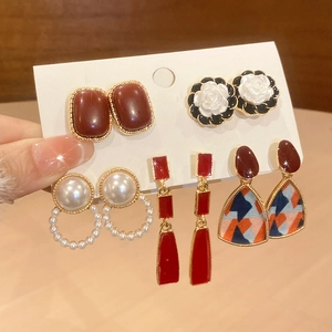 Close-up of a 5-pair set of heart pearl earrings with red enamel and floral accents