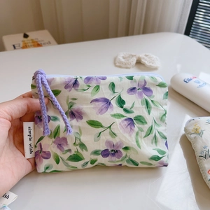 Close-up of cotton floral pouch with purple flower print and simple wish label