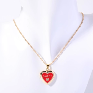 Detailed view of a gold-plated heart locket necklace with red enamel and Sweet text