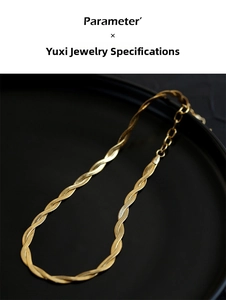Detail of 18K gold double-layer snake chain necklace with lobster clasp on dark tray