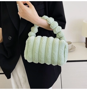 Detail of light green plush handbag with textured bubble pattern and soft handle