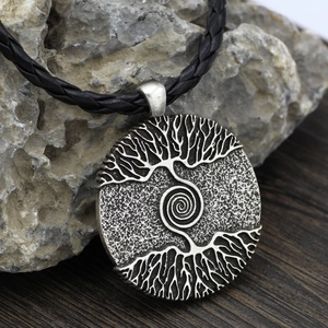Nordic Viking Yggdrasil Tree of Life pendant necklace with black braided cord on rock
