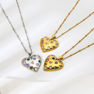 Detail of 18k gold heart pendants featuring colorful cubic zirconia on bead chains